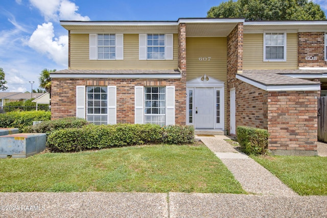 view of front facade featuring brick siding and a front lawn