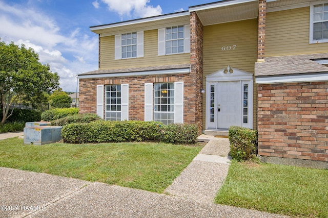 view of front facade featuring a front yard and brick siding