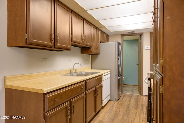 kitchen with sink, light hardwood / wood-style floors, and dishwasher