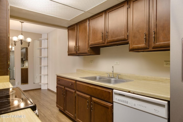 kitchen featuring sink, an inviting chandelier, decorative light fixtures, light hardwood / wood-style floors, and dishwasher