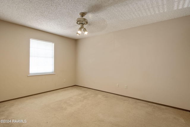 carpeted spare room featuring a textured ceiling and ceiling fan