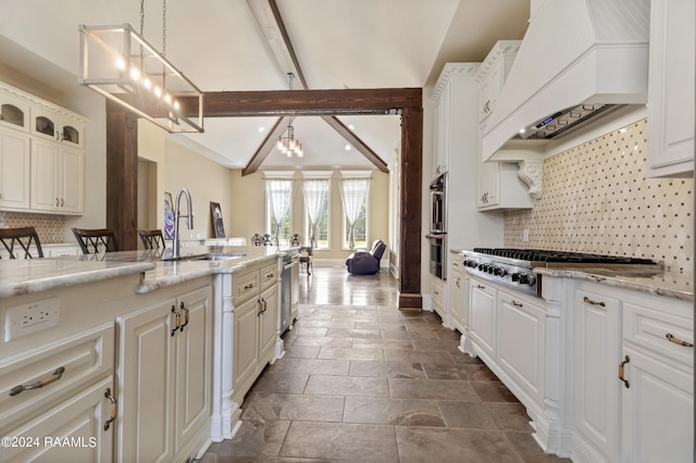 kitchen with custom range hood, glass insert cabinets, hanging light fixtures, a sink, and a notable chandelier