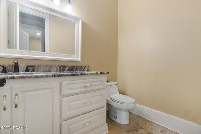 bathroom featuring tile patterned floors, vanity, and toilet