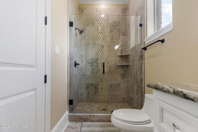 bathroom with toilet, a shower with shower door, vanity, and ornamental molding