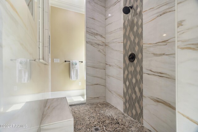 bathroom featuring tiled shower and crown molding