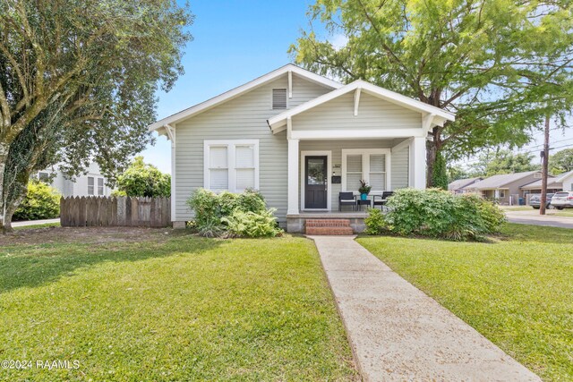 bungalow-style home with a front lawn and a porch