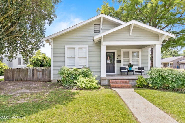 bungalow-style house featuring a porch and a front yard