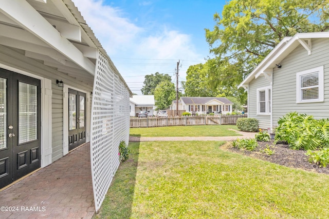 view of yard with fence and french doors