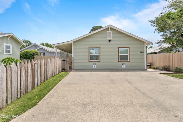 back of house with driveway and fence