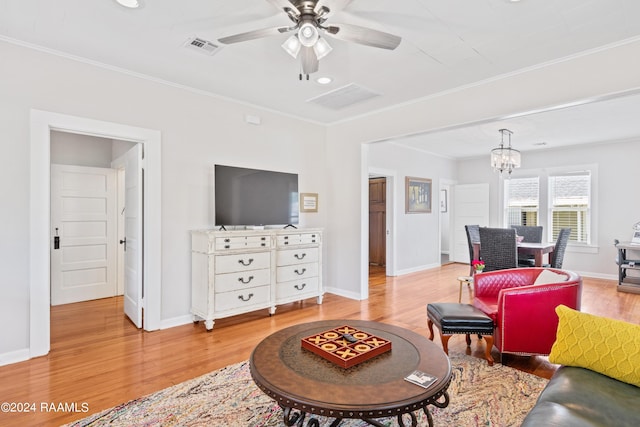 living room with baseboards, ornamental molding, wood finished floors, and ceiling fan with notable chandelier