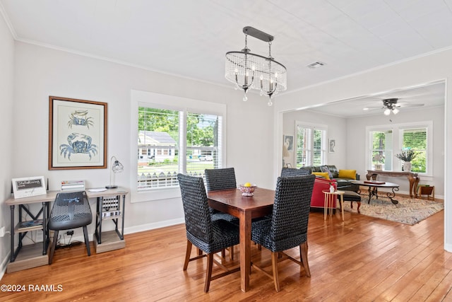 dining area featuring a healthy amount of sunlight, light wood finished floors, visible vents, and crown molding