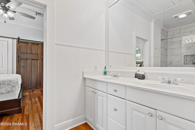 full bathroom with visible vents, ornamental molding, a sink, and wood finished floors