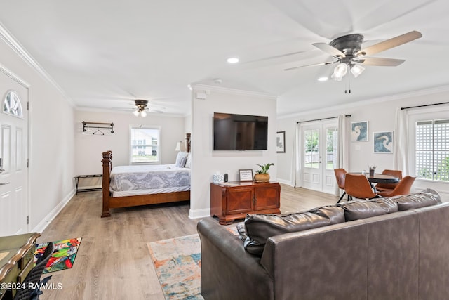 living room featuring light wood-style flooring, baseboards, crown molding, and french doors