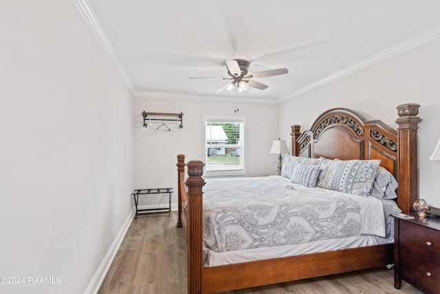 bedroom with ceiling fan, crown molding, baseboards, and wood finished floors