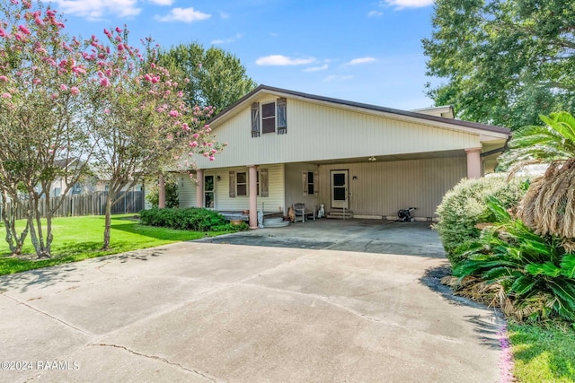 935 Pearl St, Rayne, LA 70578 - rear view of property featuring entry steps, an attached carport, fence, driveway, and a lawn
