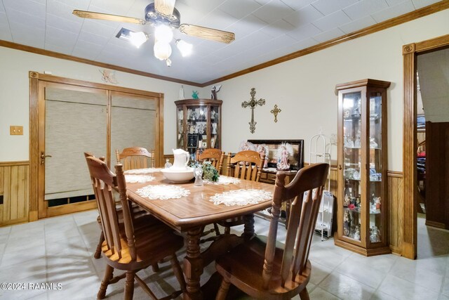 935 Pearl St, Rayne, LA 70578 - dining area with ornamental molding, wood walls, wainscoting, and a ceiling fan