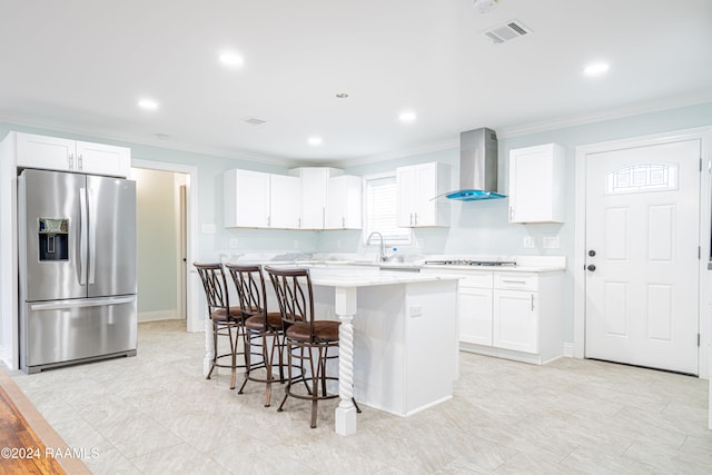 kitchen featuring a kitchen island, white cabinetry, ornamental molding, wall chimney exhaust hood, and stainless steel refrigerator with ice dispenser