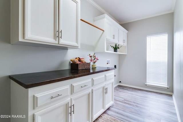 kitchen with white cabinets, light hardwood / wood-style flooring, and crown molding