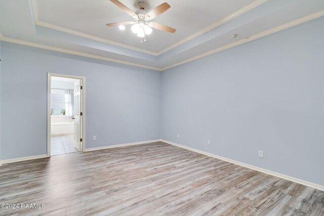 spare room featuring hardwood / wood-style floors, a raised ceiling, ornamental molding, and ceiling fan