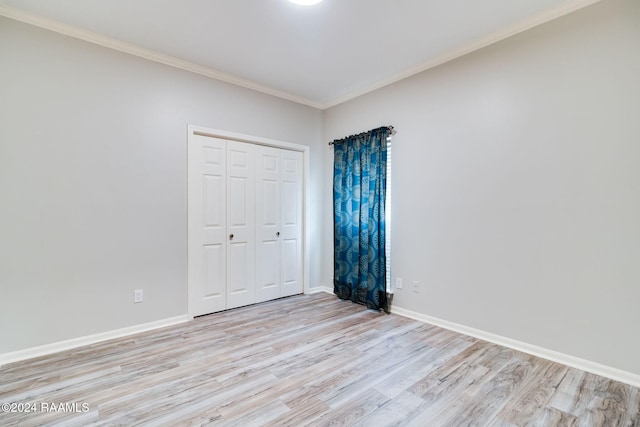 unfurnished bedroom with a closet, light hardwood / wood-style flooring, and crown molding