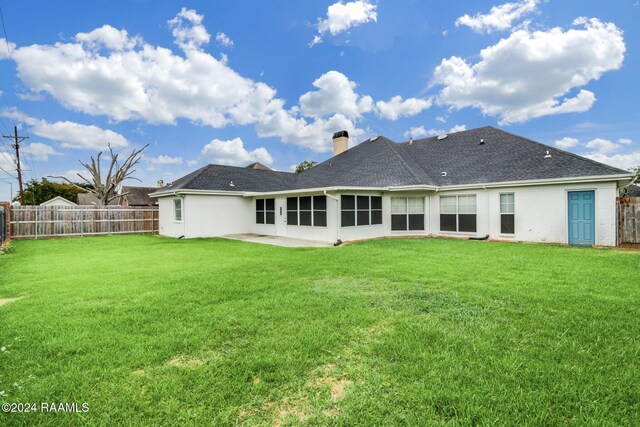 rear view of property with a yard