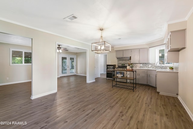 kitchen with stainless steel range, tasteful backsplash, gray cabinets, and dark hardwood / wood-style flooring