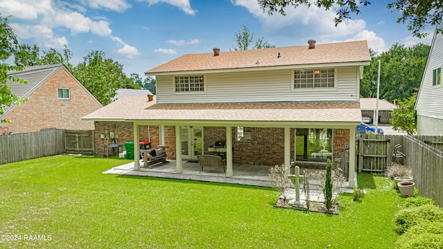 back of property with a yard and a patio