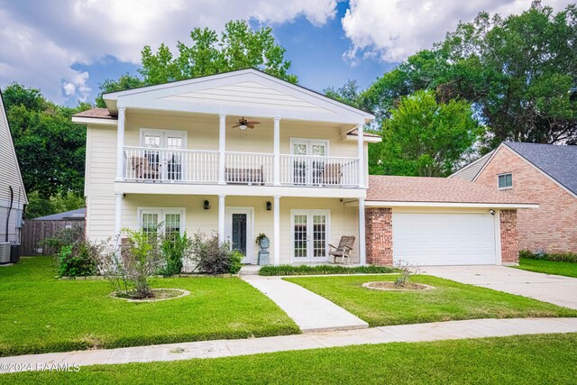 view of front facade featuring ceiling fan, french doors, a balcony, a front lawn, and a garage