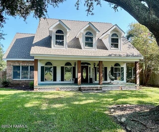 cape cod home featuring covered porch and a front yard