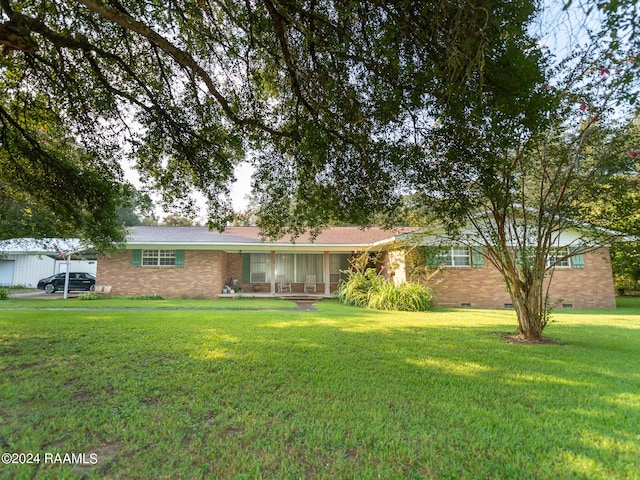 ranch-style house with a carport, a front yard, crawl space, and brick siding