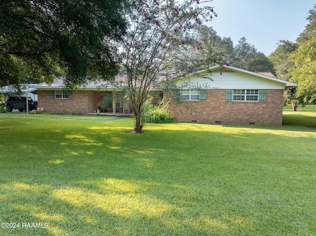 view of front of property featuring brick siding, crawl space, and a front yard