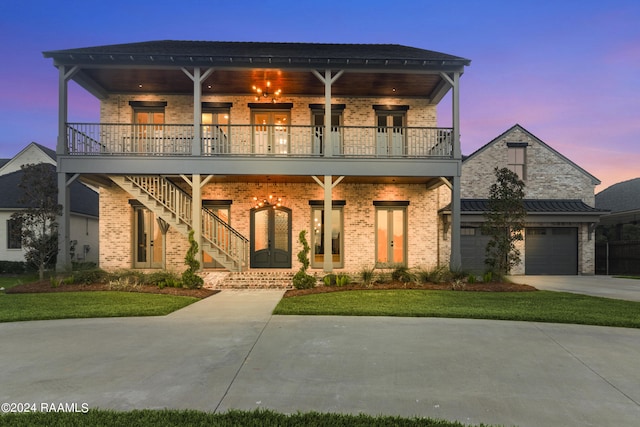 view of front of home featuring a lawn, a balcony, and a garage