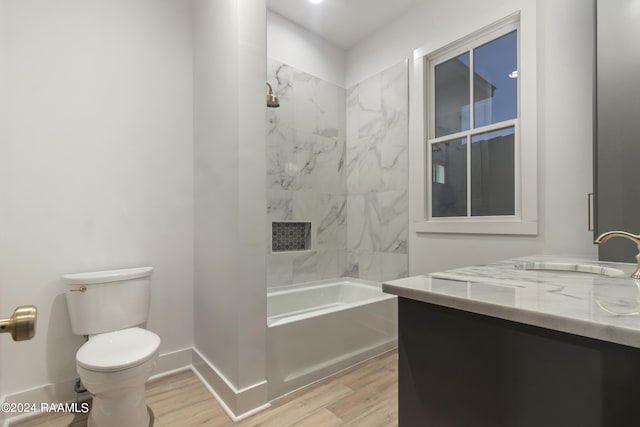 full bathroom featuring vanity, tiled shower / bath combo, toilet, and hardwood / wood-style flooring