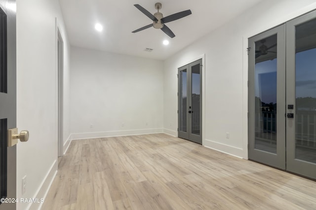 unfurnished room with light hardwood / wood-style flooring, ceiling fan, and french doors