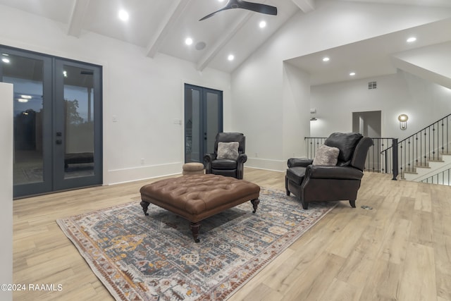 sitting room with light wood-type flooring, beamed ceiling, and high vaulted ceiling