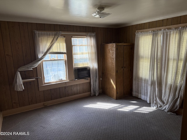 empty room with wooden walls, cooling unit, and carpet floors