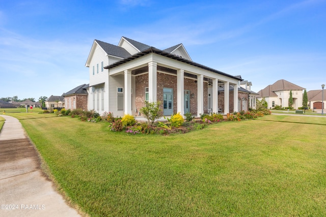 view of home's exterior with covered porch and a lawn