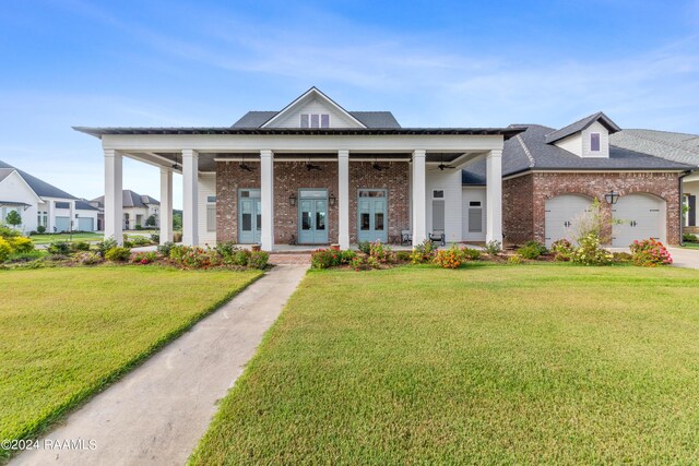 view of front of home with a front lawn, a garage, and covered porch