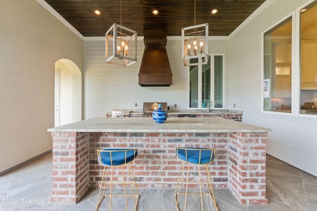 kitchen with crown molding, a center island, decorative light fixtures, and wooden ceiling