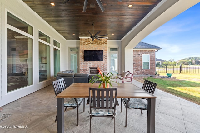 view of patio / terrace with an outdoor living space with a fireplace and ceiling fan