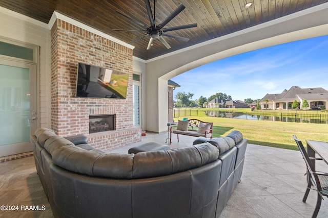 view of patio with an outdoor brick fireplace and ceiling fan