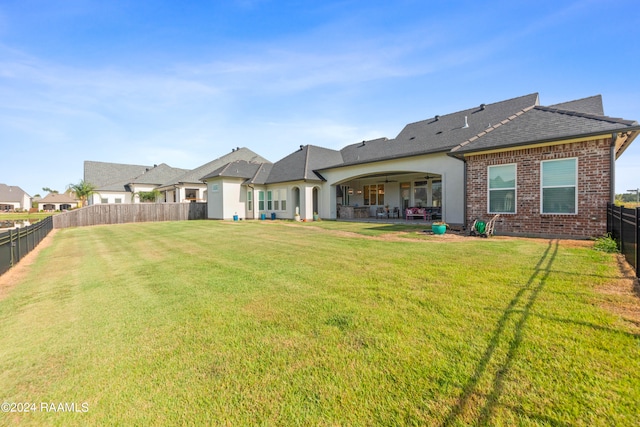 back of house featuring a yard, ceiling fan, and a patio area