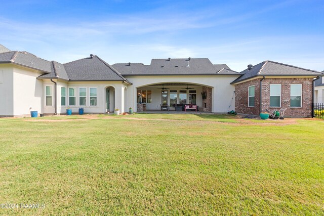 back of house with a lawn and a patio area