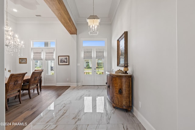 entrance foyer with ornamental molding, plenty of natural light, light hardwood / wood-style flooring, and an inviting chandelier