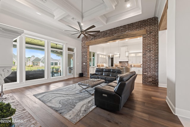 living room with ornamental molding, brick wall, dark hardwood / wood-style floors, and ceiling fan with notable chandelier