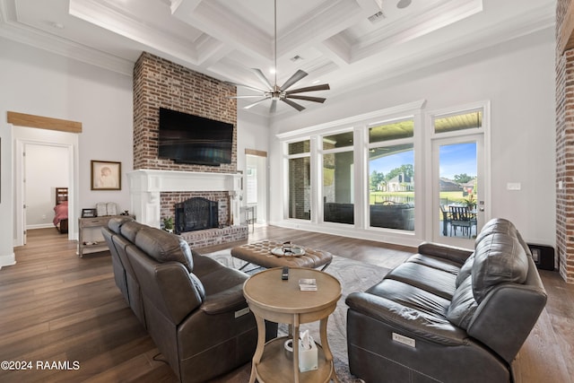 living room featuring coffered ceiling, dark hardwood / wood-style floors, a high ceiling, a brick fireplace, and ceiling fan