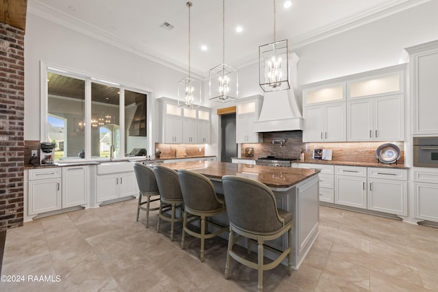 kitchen with dark stone countertops, a kitchen island, backsplash, and crown molding