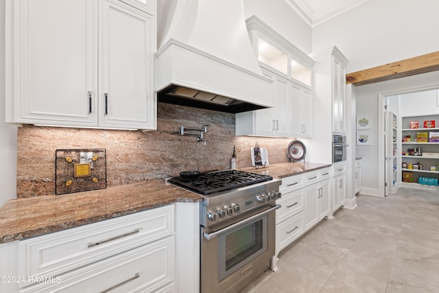 kitchen featuring white cabinets, crown molding, stone counters, custom exhaust hood, and stainless steel appliances