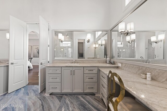 bathroom with vanity, an inviting chandelier, and a shower with shower door