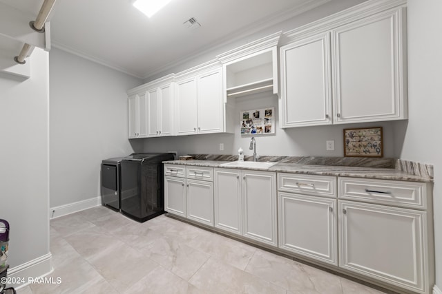 kitchen featuring crown molding, white cabinetry, light stone counters, sink, and washing machine and dryer